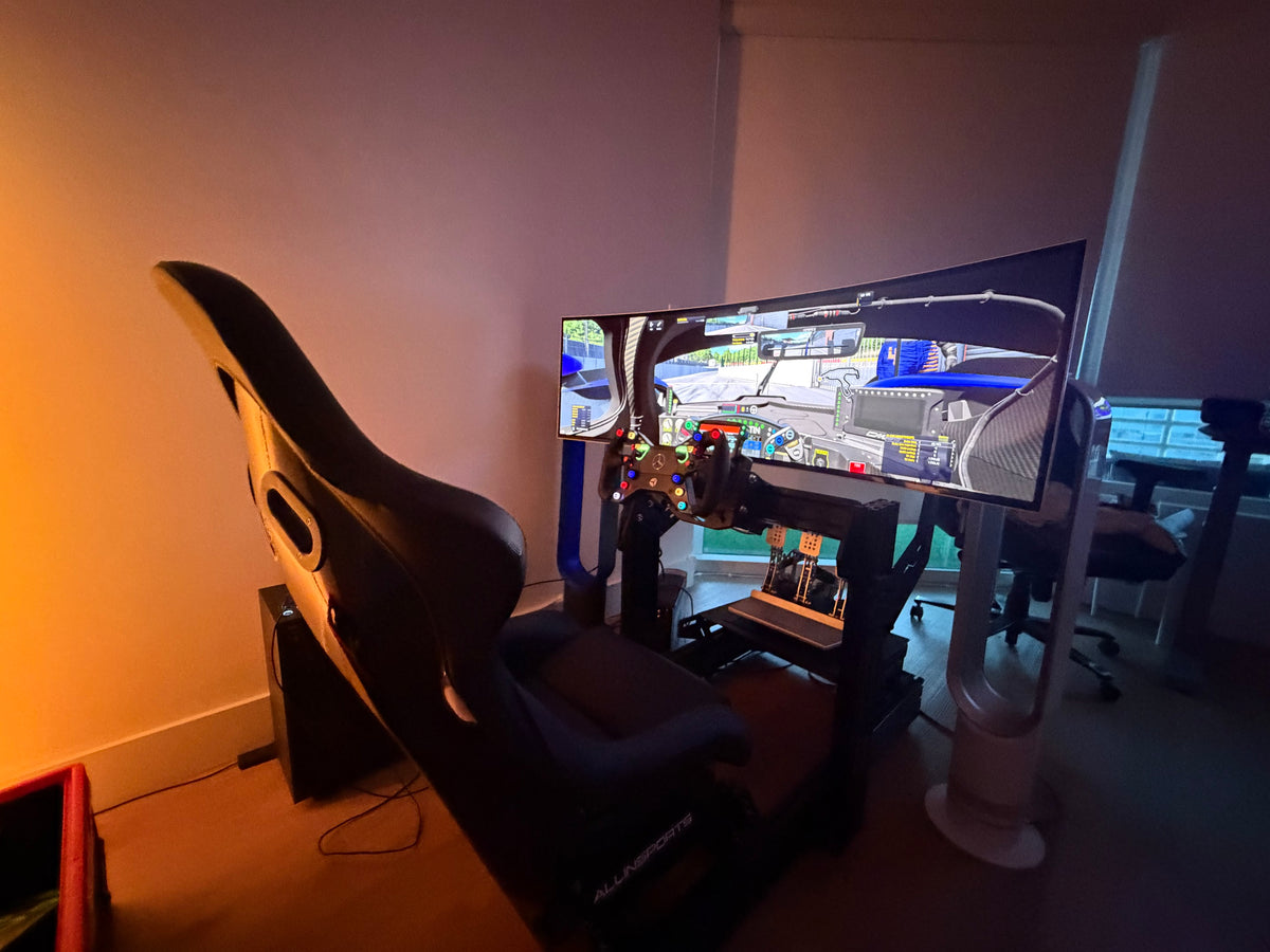 Completed sim racing build on track in a customer's room, GT seating position with a GT wheel, three pedal set and a curved ultrawide screen